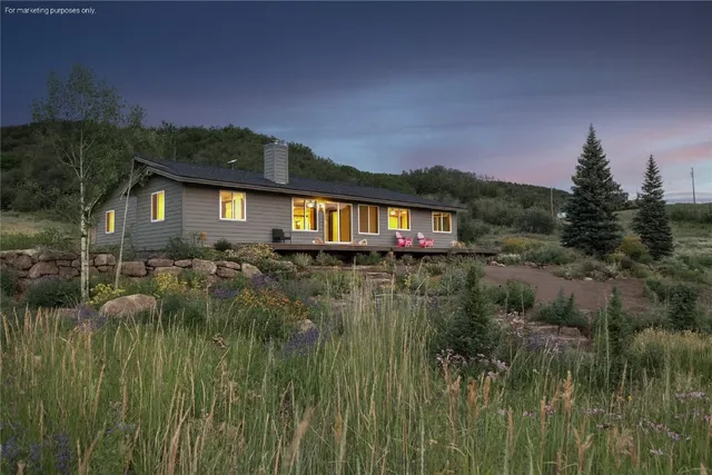 a view of backyard of house along with deck and outdoor seating