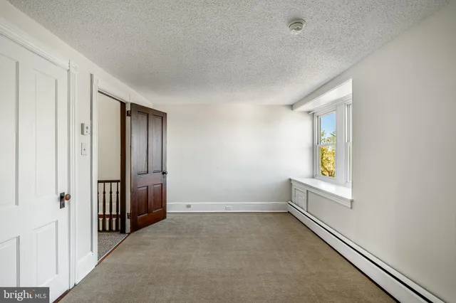 a view of a hallway with wooden floor and entryway