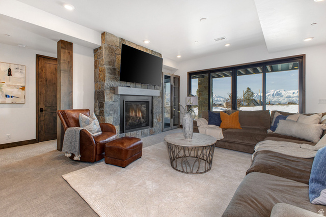 1282 Chimney Rock Road, Unit 344 Heber City, UT 84032 - Photo 31 of 55 Living area featuring a stone fireplace with a light-toned mantle, recessed lighting, and a large window overlooking a snowy mountain landscape
