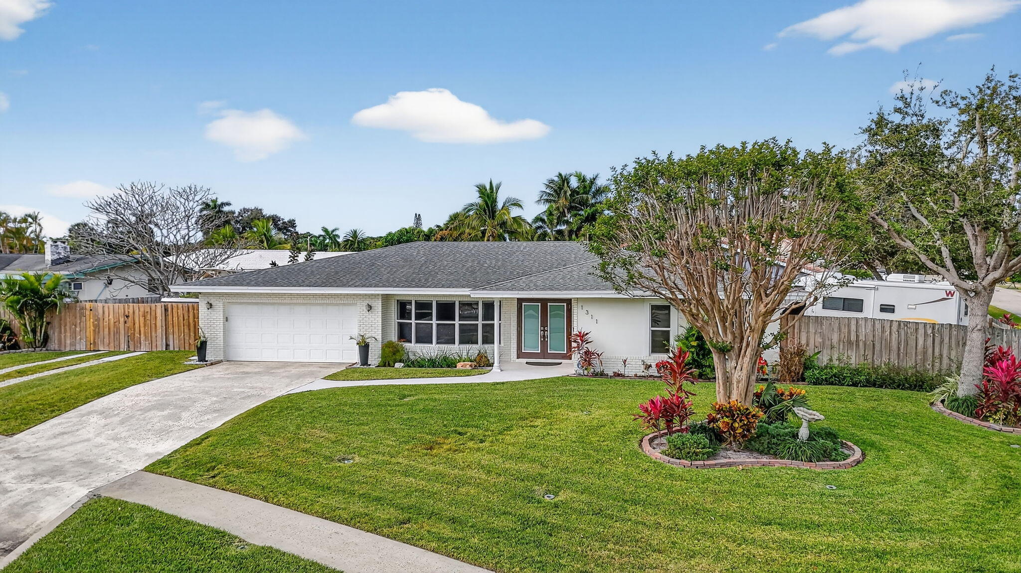 1311 Southwest 14th Avenue Boca Raton, FL 33486 - Photo 48 of 54 a front view of house with a garden and patio
