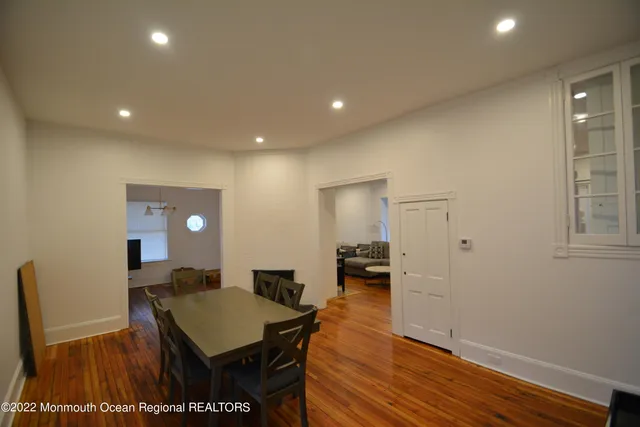 a living room with furniture a wooden floor and next to a window