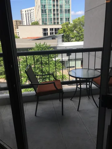 a balcony with wooden floor outdoor seating and city view