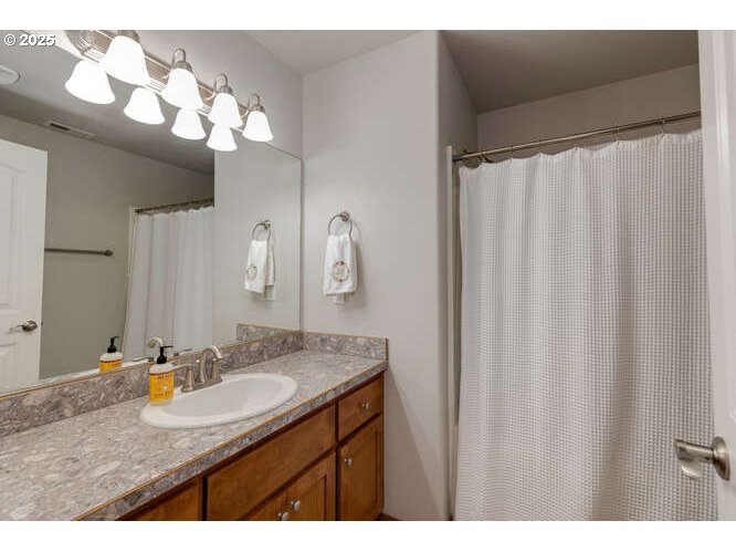 433 Southwest Pemberly Loop McMinnville, OR 97128 - Photo 18 of 24 a bathroom with a granite countertop sink a mirror and a shower