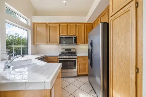 a kitchen with granite countertop a refrigerator stove top oven and sink