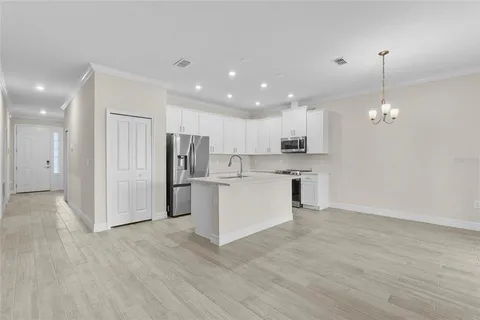 a kitchen with white cabinets and refrigerator