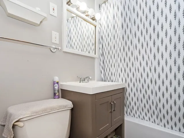 a bathroom with a sink a toilet and a window