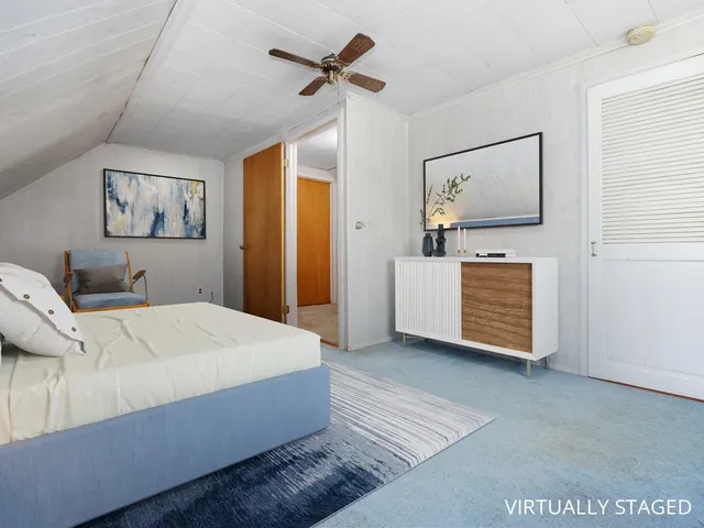 a room with a bed and ceiling fan