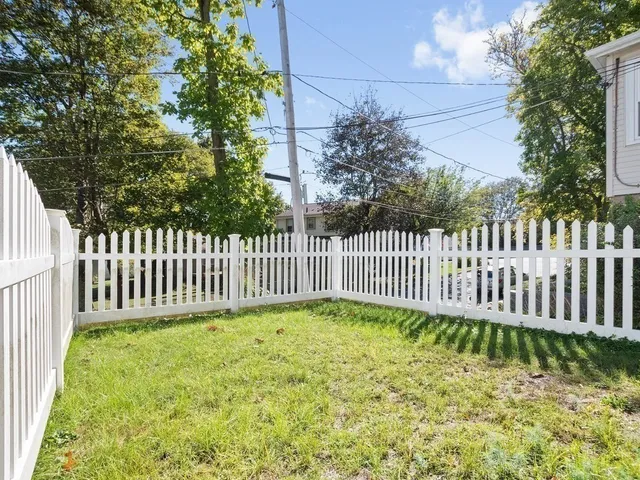a view of a yard with wooden fence