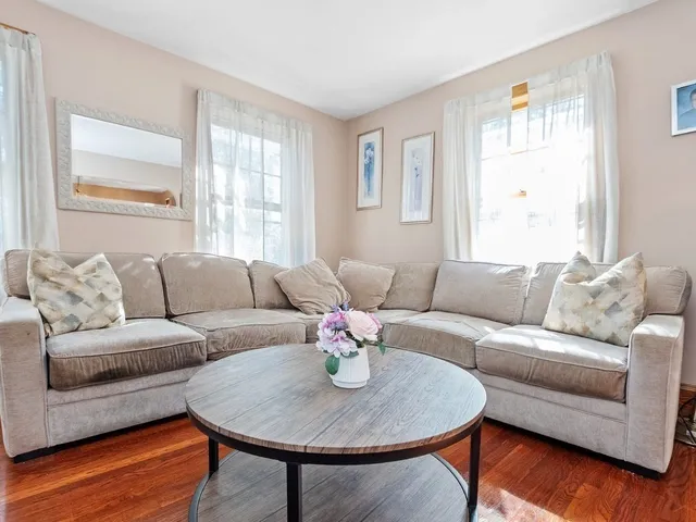 a living room with furniture wooden floor and a window
