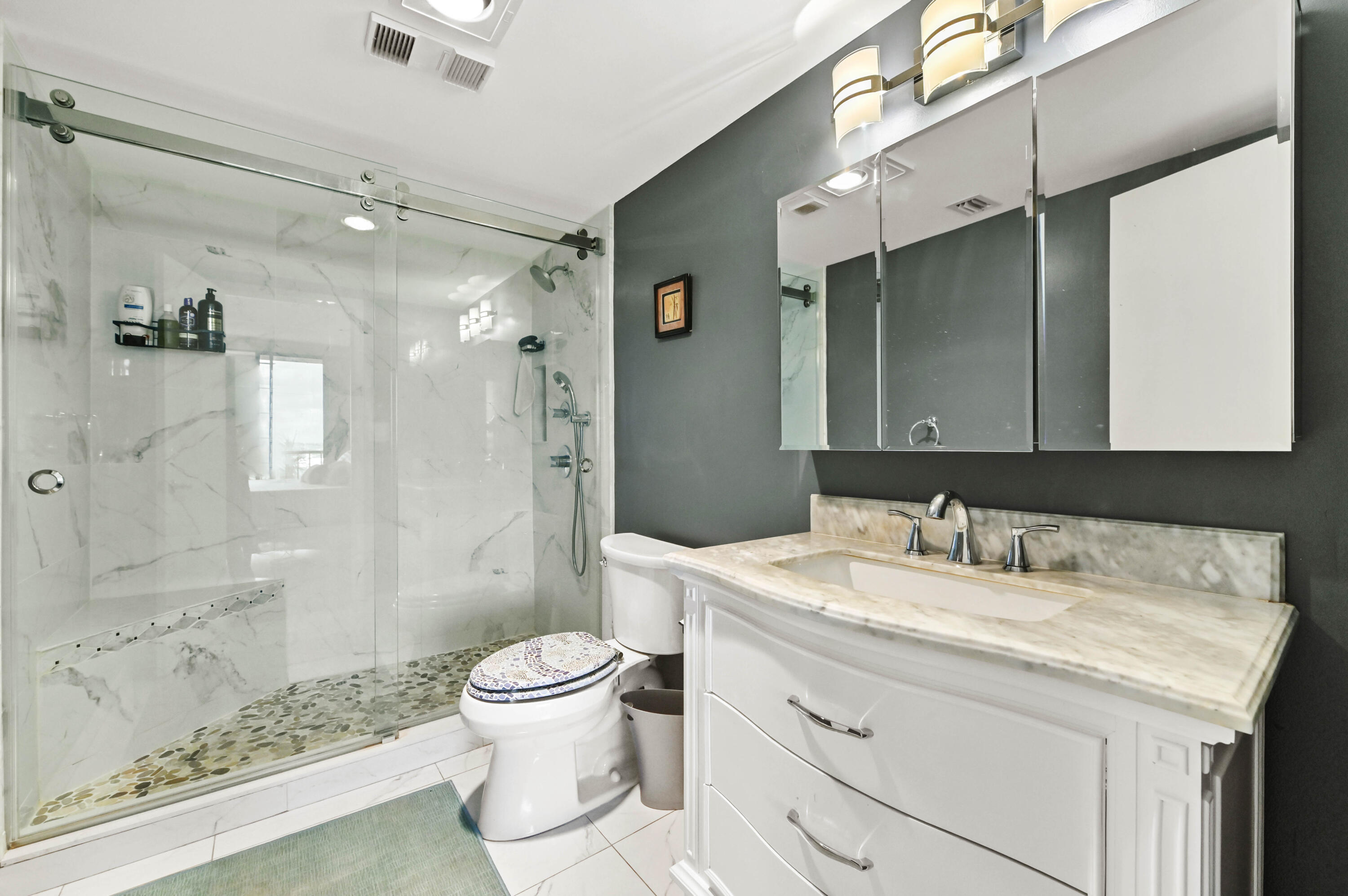 5951 Wellesley Park Drive, Unit 702 Boca Raton, FL 33433 - Photo 14 of 26 a bathroom with a granite countertop sink a toilet a mirror and shower