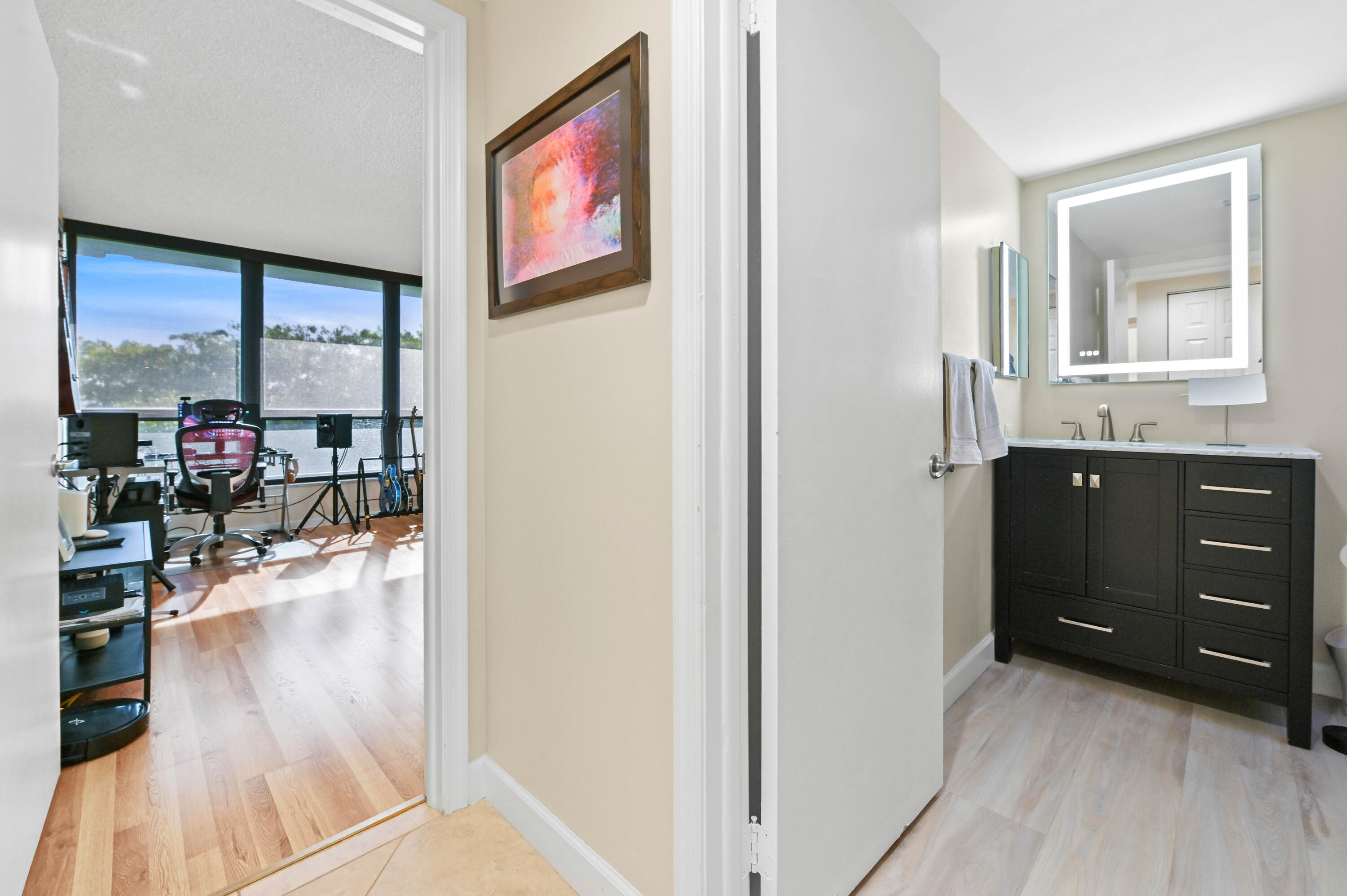 5951 Wellesley Park Drive, Unit 702 Boca Raton, FL 33433 - Photo 19 of 26 a hallway with a large window and wooden floor