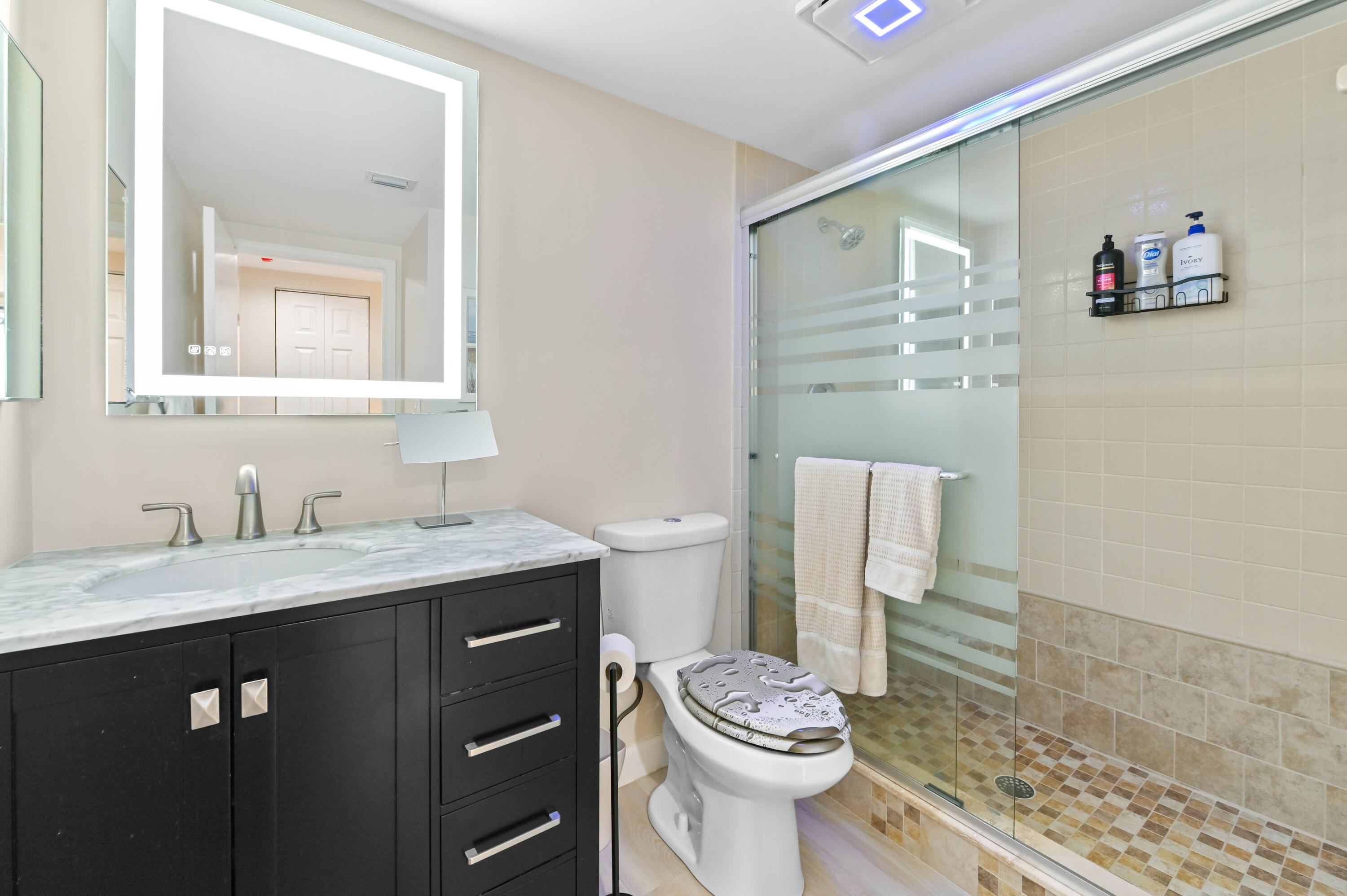 5951 Wellesley Park Drive, Unit 702 Boca Raton, FL 33433 - Photo 21 of 26 a bathroom with a granite countertop sink mirror vanity and toilet