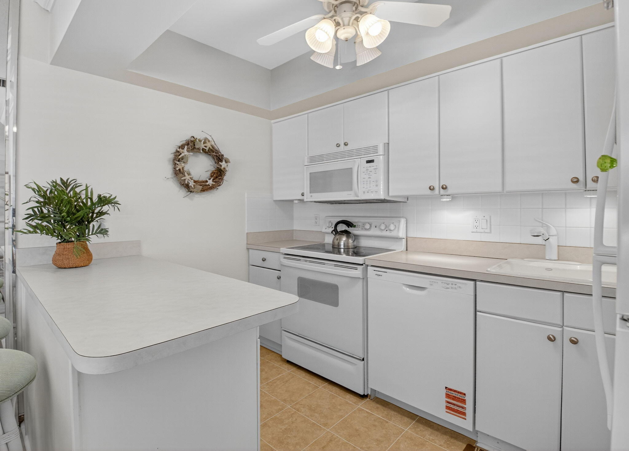 5505 North Ocean Boulevard, Unit 8204 Ocean Ridge, FL 33435 - Photo 12 of 47 a kitchen with a white cabinets and white appliances