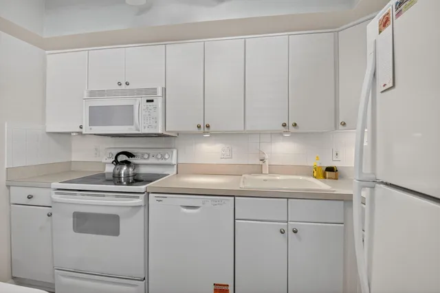 a white refrigerator freezer sitting inside of a kitchen