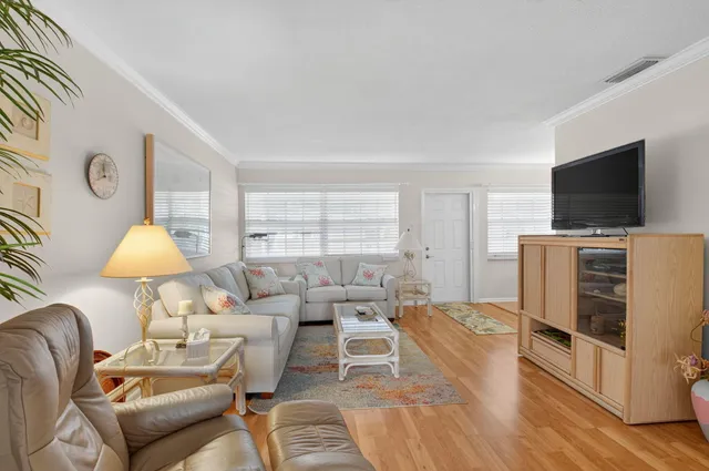 a dining room with wooden floor a chandelier a wooden table and chairs