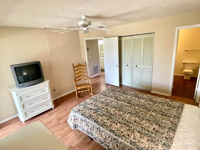 1225 Northwest 21st Street, Unit 343414 Stuart, FL 34994 - Photo 12 of 31 a bedroom with a bed and flat screen tv
