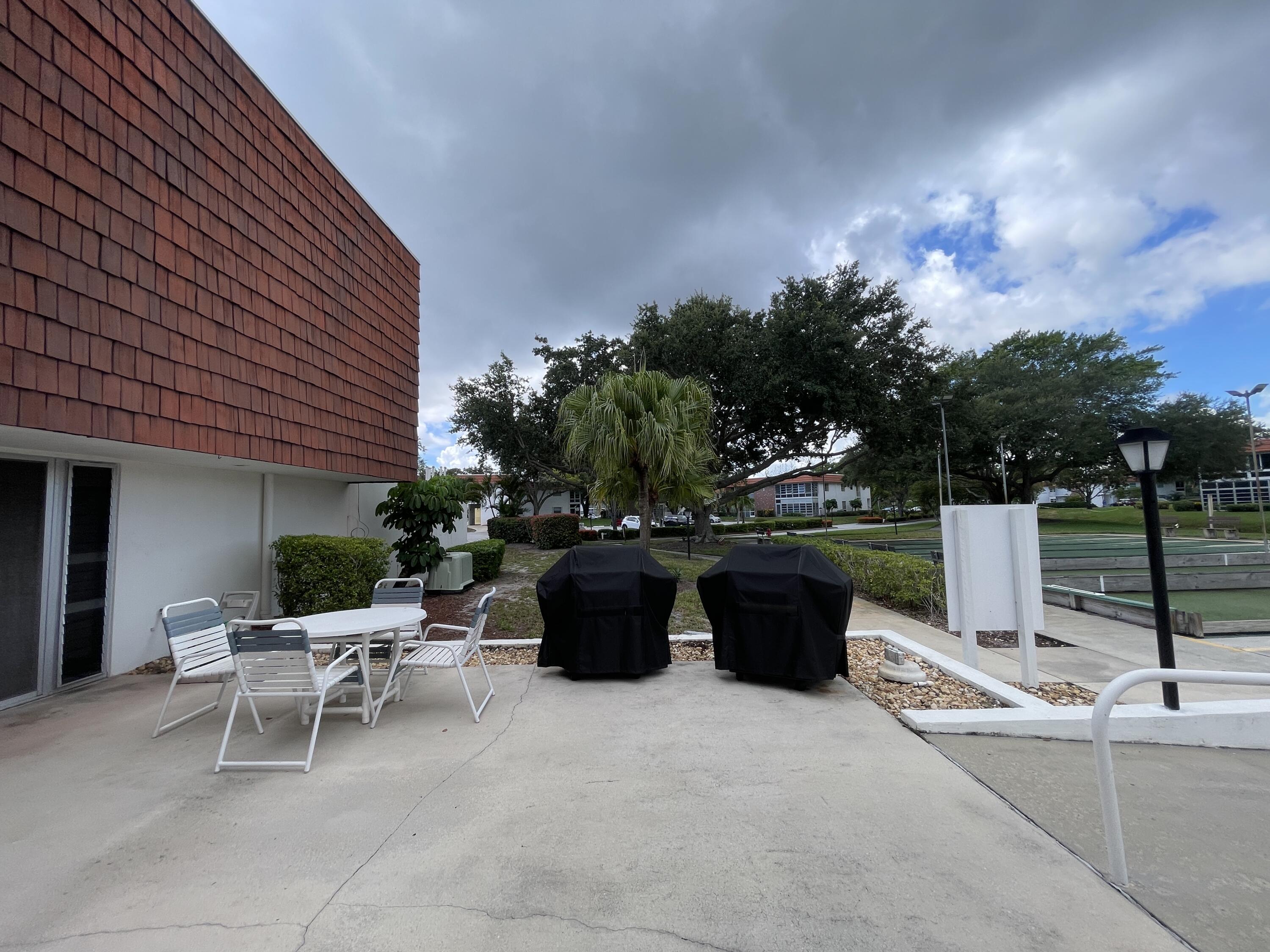 1225 Northwest 21st Street, Unit 343414 Stuart, FL 34994 - Photo 22 of 31 a view of a patio with chairs and tables