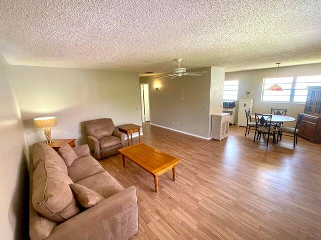 1225 Northwest 21st Street, Unit 343414 Stuart, FL 34994 - Photo 4 of 31 a living room with furniture and a wooden floor