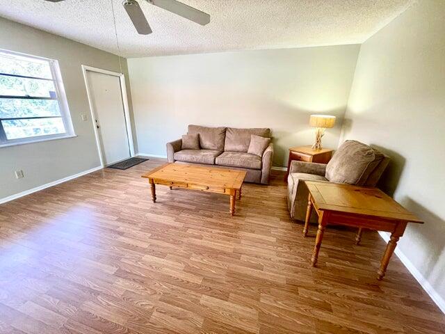 1225 Northwest 21st Street, Unit 343414 Stuart, FL 34994 - Photo 5 of 31 a living room with furniture and a wooden floor