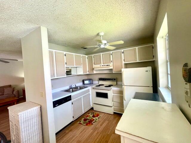 1225 Northwest 21st Street, Unit 343414 Stuart, FL 34994 - Photo 9 of 31 a kitchen with a sink a stove and refrigerator