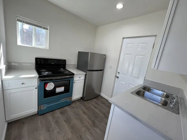 a kitchen with white cabinets and sink