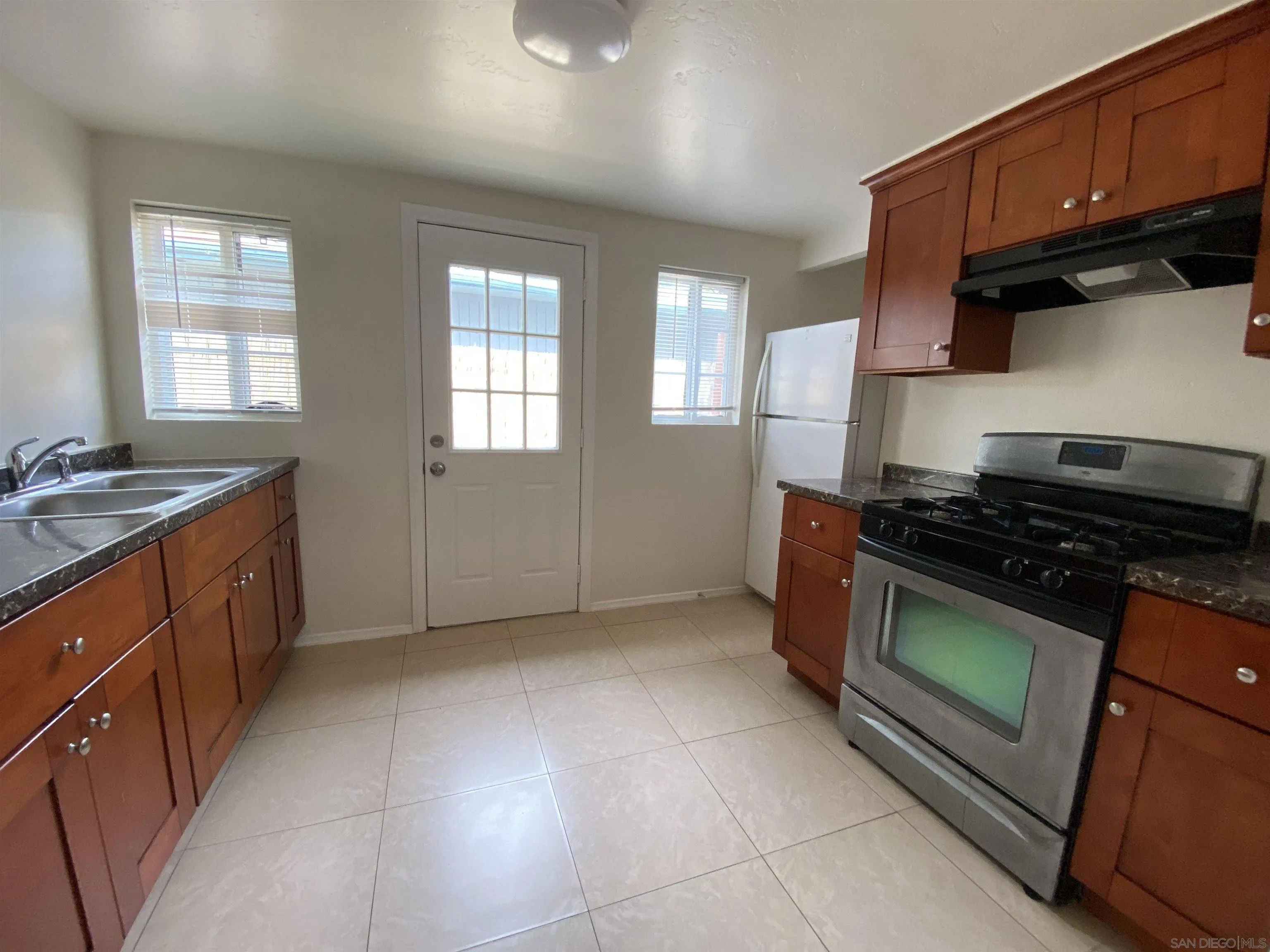 1223 Division Street Oceanside, CA 92054 - Photo 4 of 14 a kitchen with granite countertop a stove and a sink
