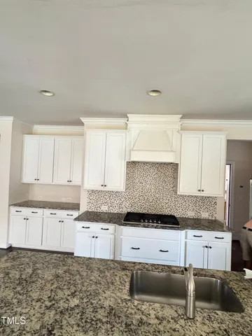 a kitchen with granite countertop a sink and cabinets