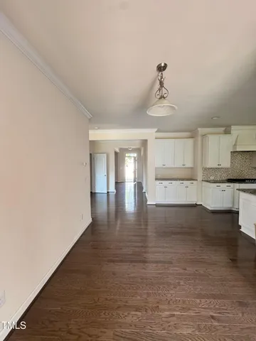 a view of empty room with wooden floor and windows