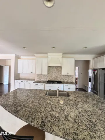 a large kitchen with kitchen island granite countertop a sink and cabinets