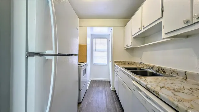 a kitchen with a stove and a wooden floor