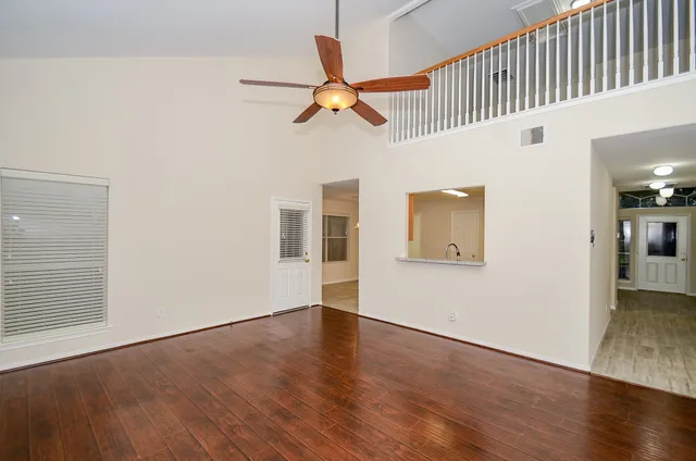 a view of a livingroom with wooden floor and a ceiling fan