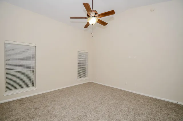 an empty room with a window and a fan