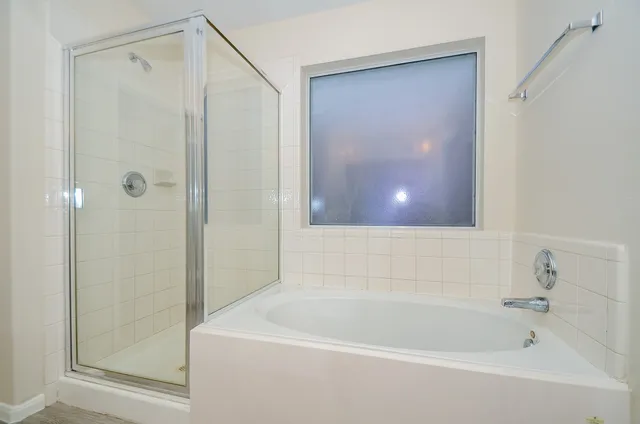 a white bath tub sitting next to a shower