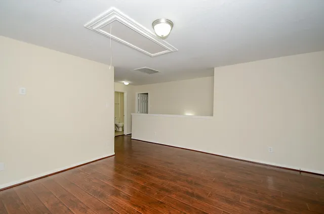 a view of an empty room with wooden floor