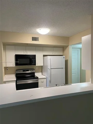 a kitchen with kitchen island a refrigerator and a stove