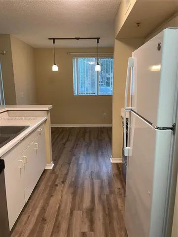 a view of a kitchen from a hallway