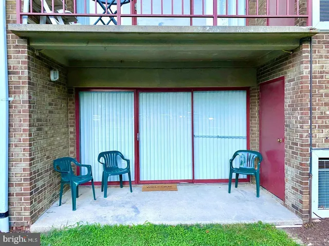 a view of a chair and table in backyard of the house