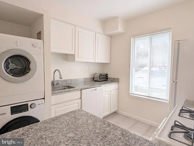 a kitchen with stainless steel appliances granite countertop a sink a stove a refrigerator and cabinets