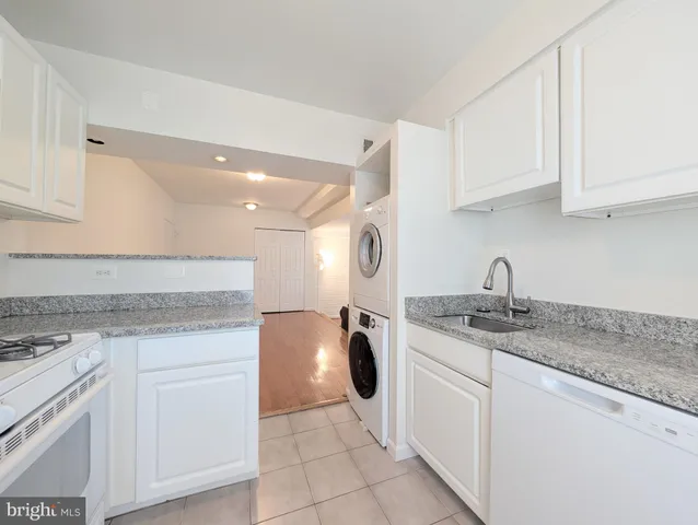 a kitchen with white cabinets appliances and sink