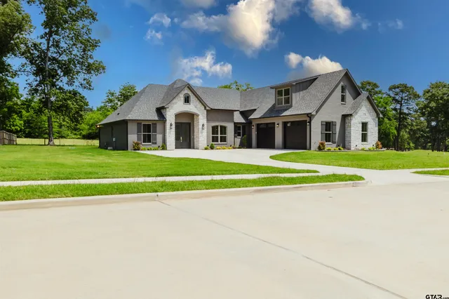 a front view of a house with a yard and trees