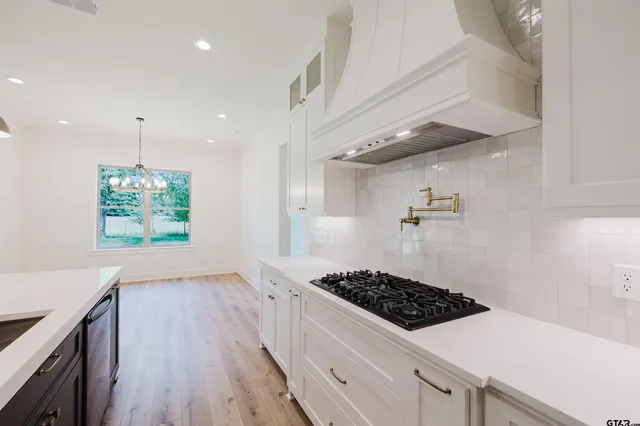 a kitchen with stove and wooden floor