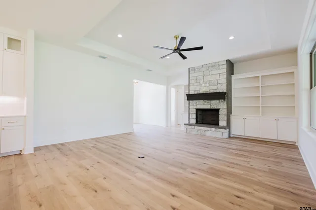 a view of empty room with wooden floor and fireplace