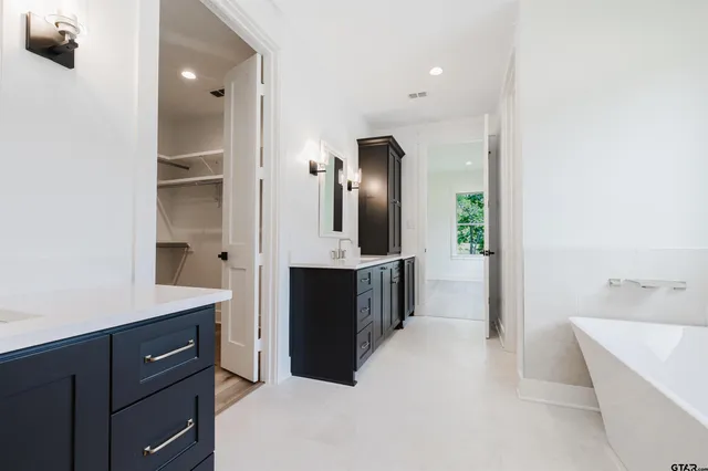a spacious bathroom with a tub and mirror