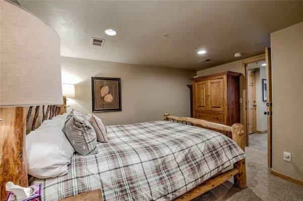 a bedroom with a large bed and a chandelier