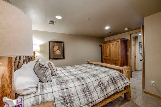 a bedroom with a large bed and a chandelier