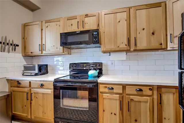 a kitchen with stainless steel appliances a stove a microwave and cabinets
