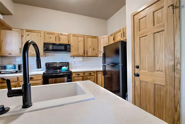a kitchen with stainless steel appliances granite countertop a refrigerator and a stove top oven