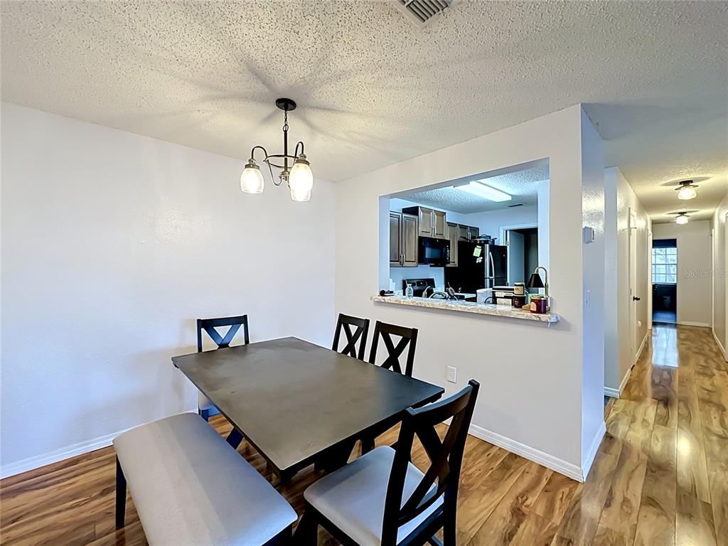 3705 Southwest 27th Street, Unit 922 Gainesville, FL 32608 - Photo 6 of 34 a view of a dining room with furniture and wooden floor
