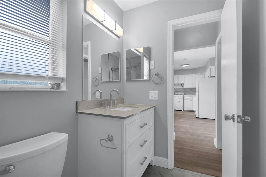 4751 Northeast 21st Terrace, Unit 4 Lighthouse Point, FL 33064 - Photo 14 of 22 a bathroom with a granite countertop sink toilet and shower