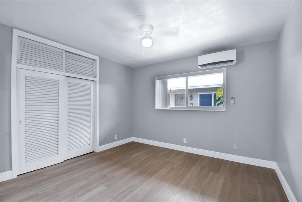 4751 Northeast 21st Terrace, Unit 4 Lighthouse Point, FL 33064 - Photo 18 of 22 a view of an empty room with wooden floor and a window